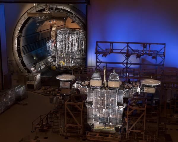 AEHF-4 (foreground) with the antenna wings extended and AEHF-5 (background) visible in the open DELTA chamber.