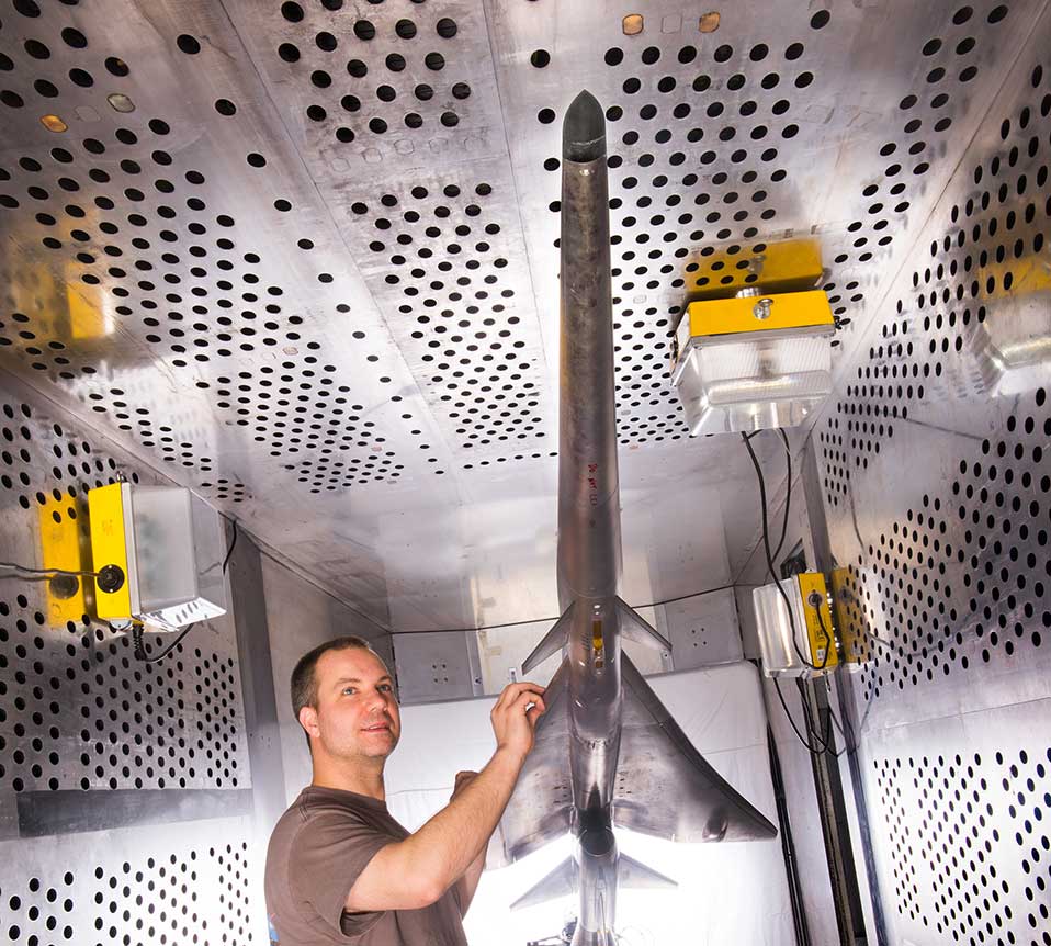 Mechanical technician Dan Pitts prepares the model for wind tunnel testing.  Credit: NASA  